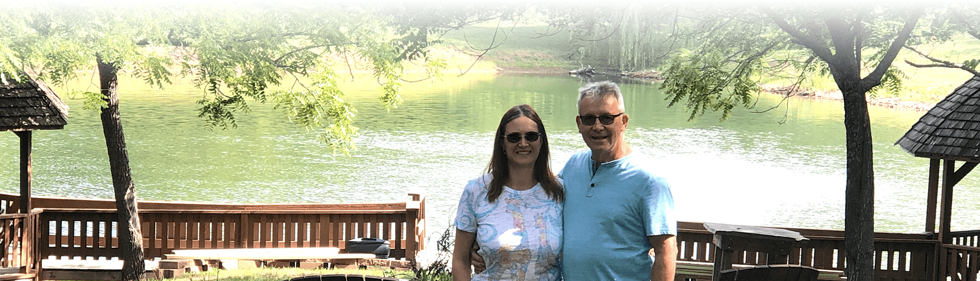 Innkeepers Karl and Rebecca in front of pond surrounded by green grass