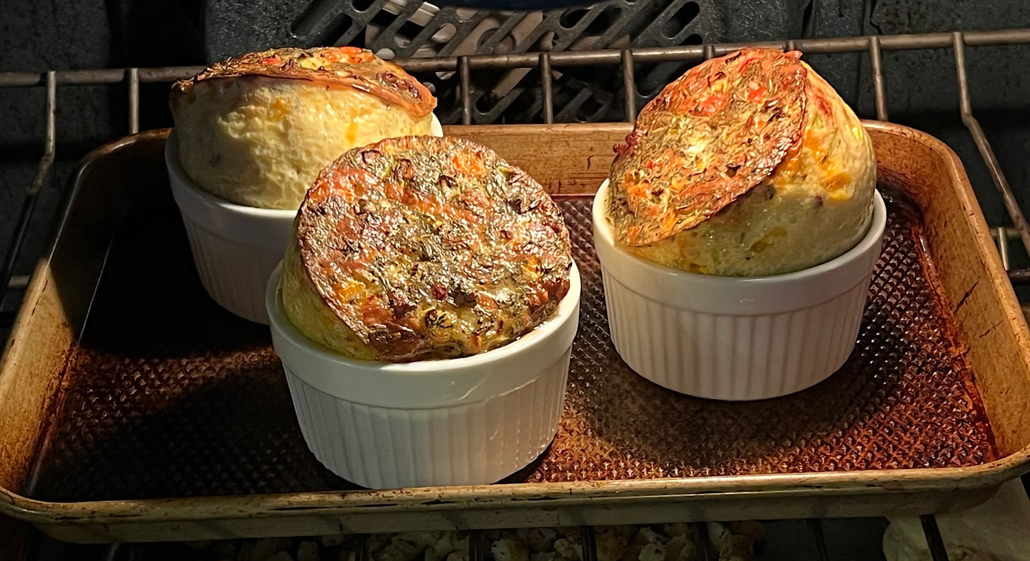 Three Egg souffle cups in oven