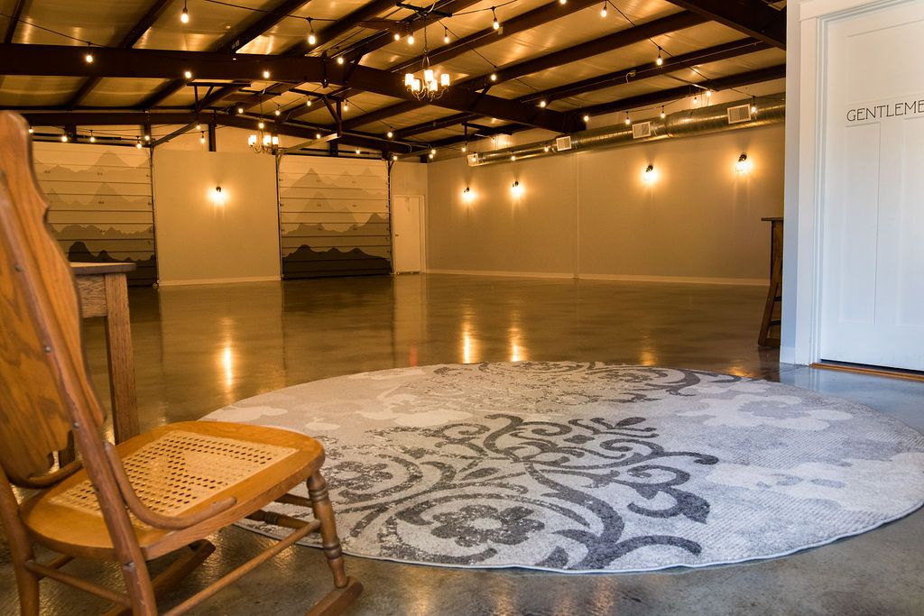open event hall with rocking chair and  grey circular rug
