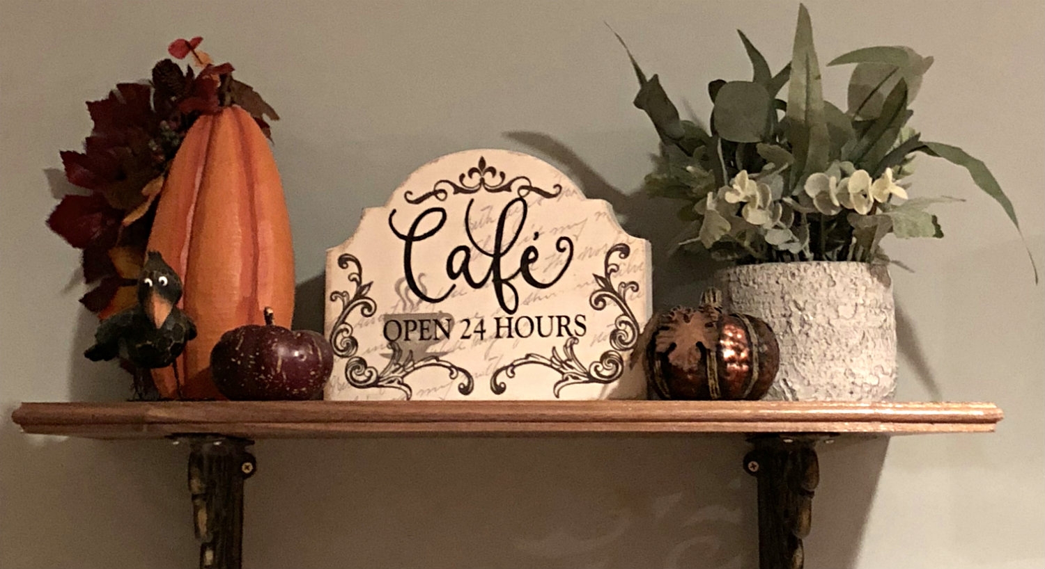 Decorative shelf with sign that reads: Cafe open 24 hours